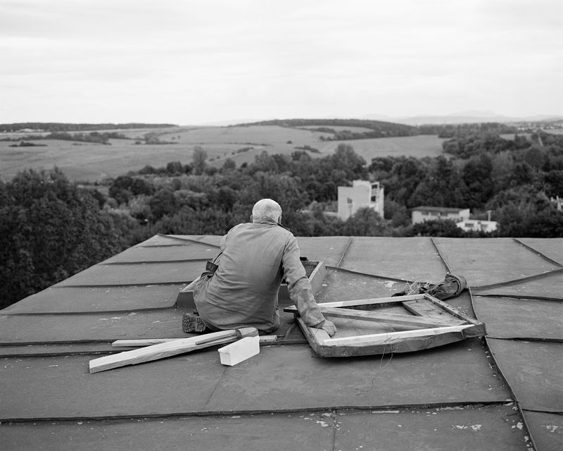 © Dominika Jackuliakova - Man taking a break from maintenance work on the roof of Podrečany mansion. Podrečany, 2022