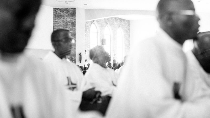 © Cole Ndelu - Priests kneeling in prayer