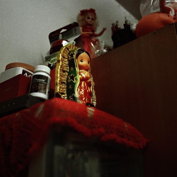 © Ruth Prieto - A Virgin of Guadalupe´s toy on the shelve. In the background a Barbie figure stands along with all the other toys.