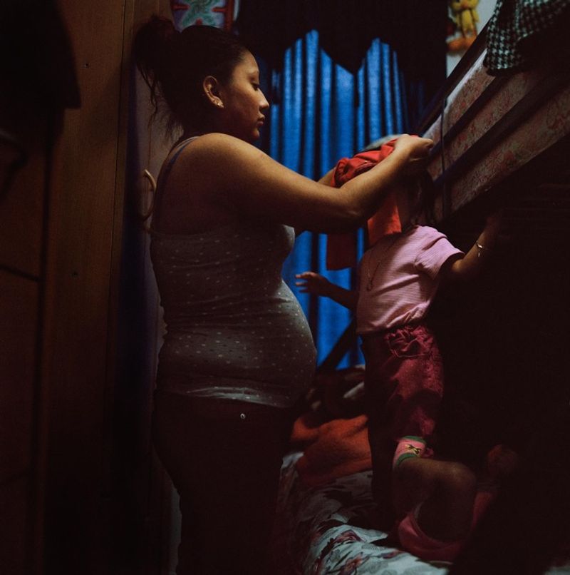 © Ruth Prieto - Maribel dresses her older daughter Sherlyne.