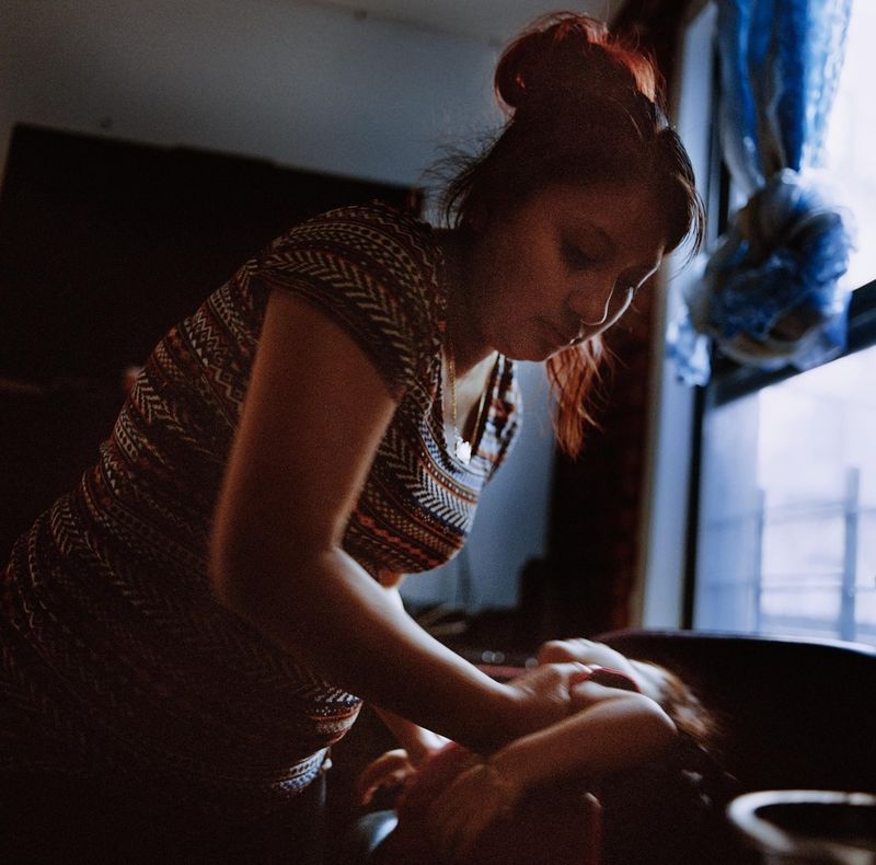 © Ruth Prieto - Maribel struggles with the kid who had been sick and refuses to eat.