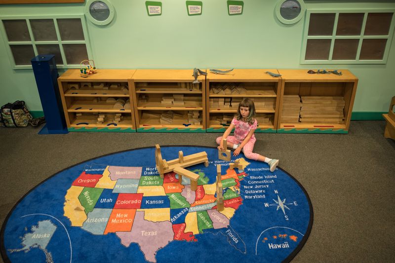 © Fulvio Bugani - Adi and the USA - Adì is playing sitting on a carpet representing the USA. She is in an educational center for kids.