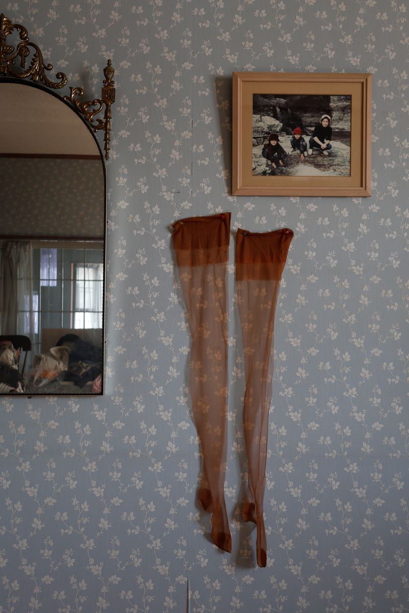 © Yuki Furusawa - My grandmother’s stockings from her youth, hung on the wall next to her favorite mirror.
