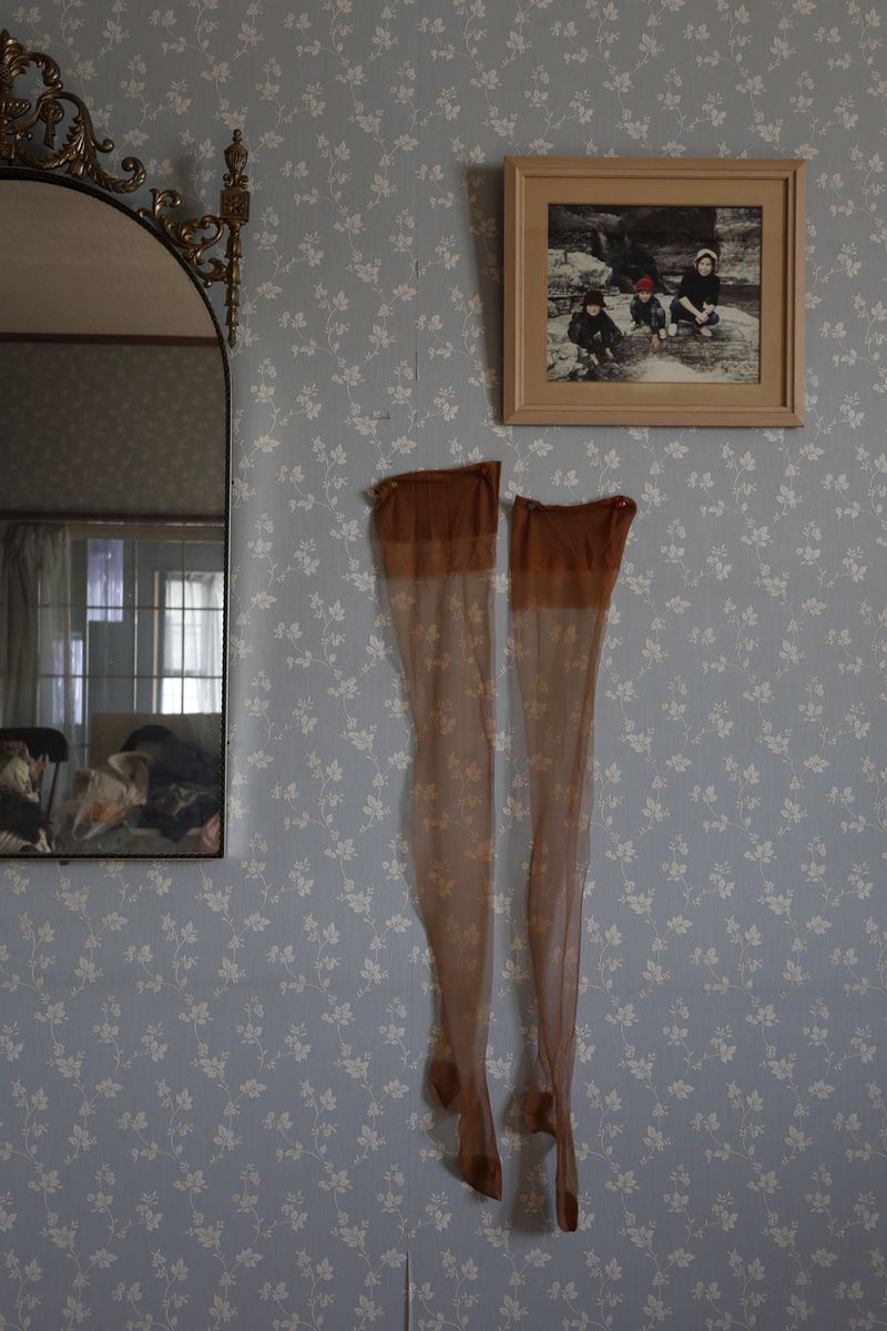 © Yuki Furusawa - My grandmother’s stockings from her youth, hung on the wall next to her favorite mirror.