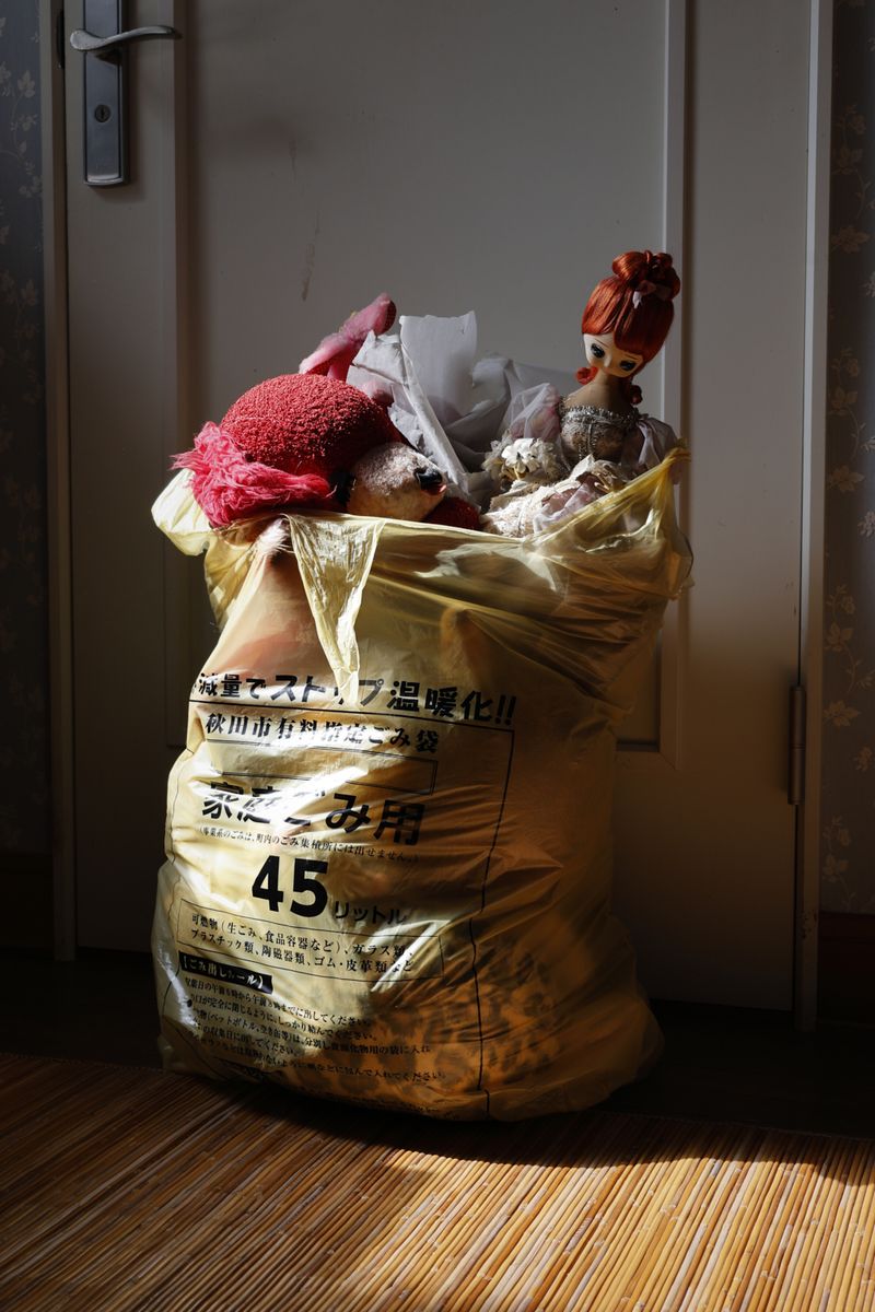 © Yuki Furusawa - Stuffed toys and dolls from my mother’s childhood, placed in a plastic trash bag.