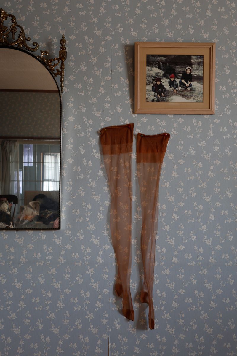 © Yuki Furusawa - My grandmother’s stockings from her youth, hung on the wall next to her favorite mirror.