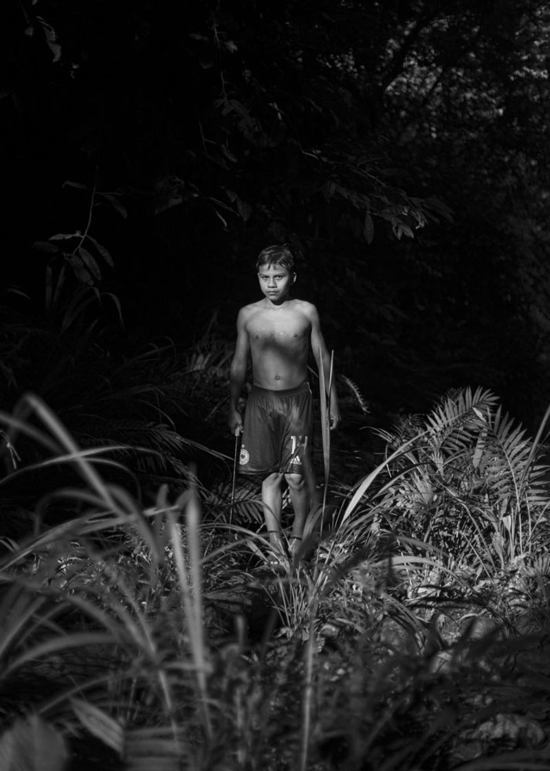© Daniela Beltran B. - A portrait of Juan Carlos, Naime's son, walking through the river next to their house.