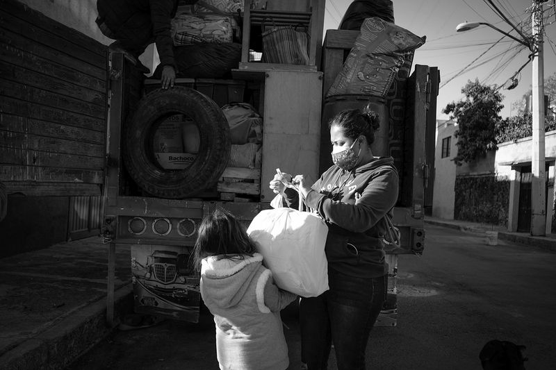 © Greta Rico - Team work. Nicole helps Siomara carry bags and small packages for the seventh move in the last four years.