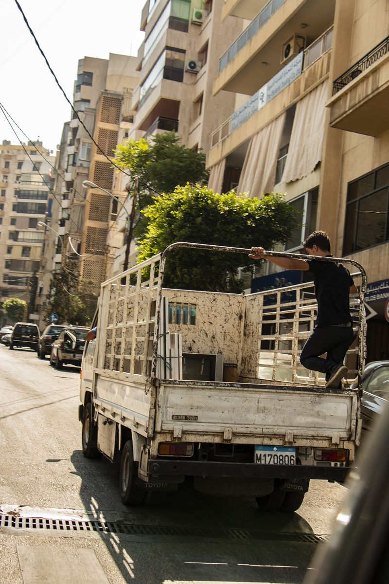 © Malak Wazne - Child Of Lebanon | A child stands in the trunk of a moving truck.