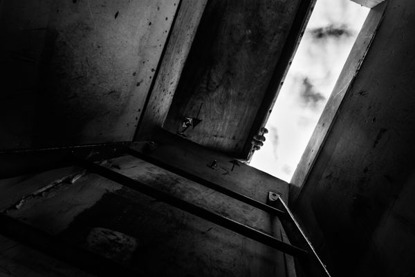 © Bastien Deschamps - Jrock opens the hatch leading to the rooftop where he keeps his birds in Bushwick, Brooklyn - March 3rd 2019