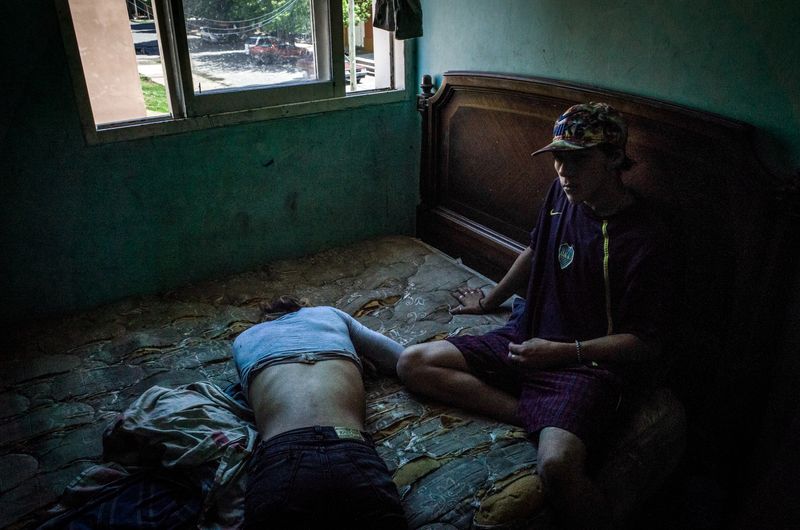 © Karl Mancini - Buenos Aires, Isla Maciel. F. and K. on a bed after a night spent consuming drugs and alcoohol in the street.