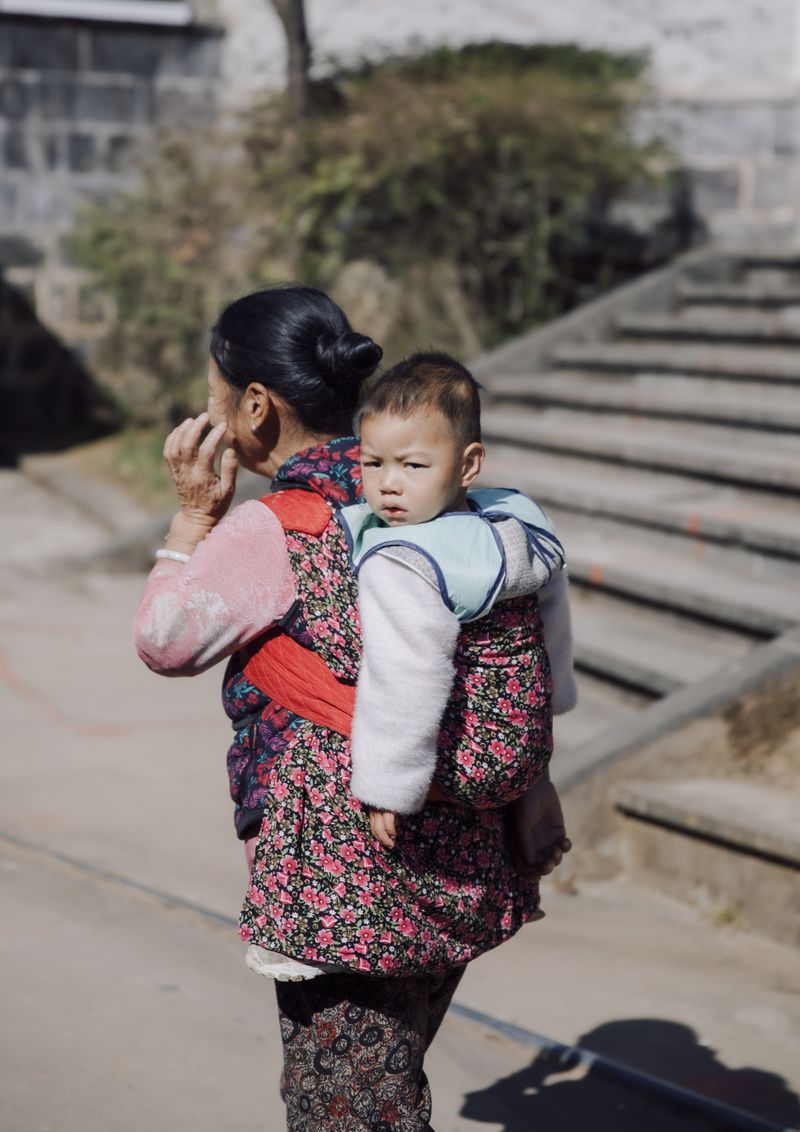 © Leafy Yun Ye - A grandma carries her grandson in a traditional baby wrap carrier in Tengchong, China, 2022.