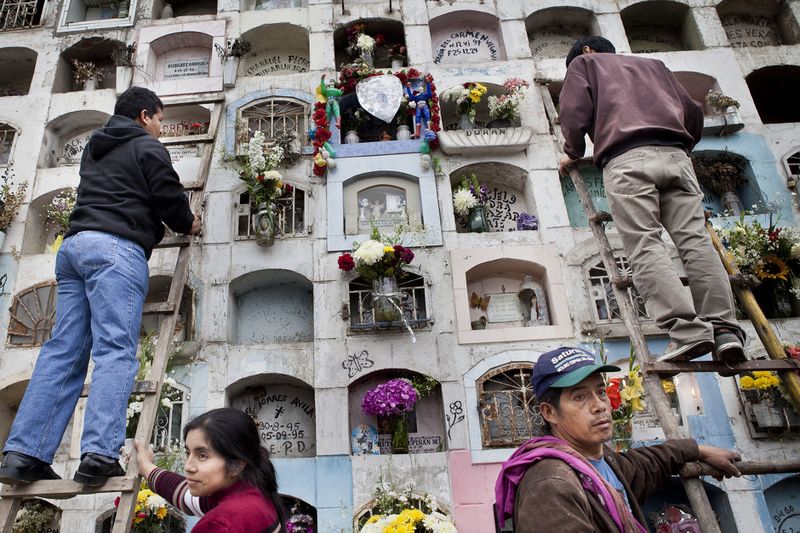 © Guillermo Gutierrez - People decorate the graves of their relatives using flowers and and small presents.