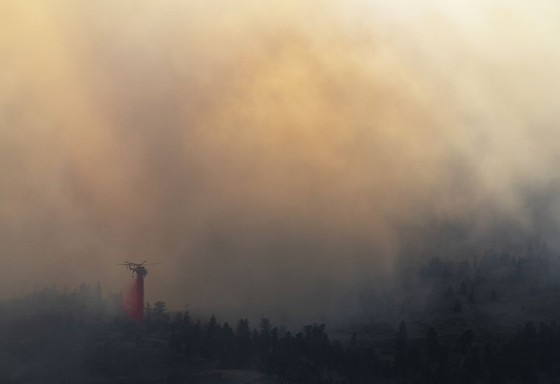 © Jessica Hays - Red Rain, 2022 – A helicopter drops fire retardant on the eastern front of a late October fire in southern Wyoming.