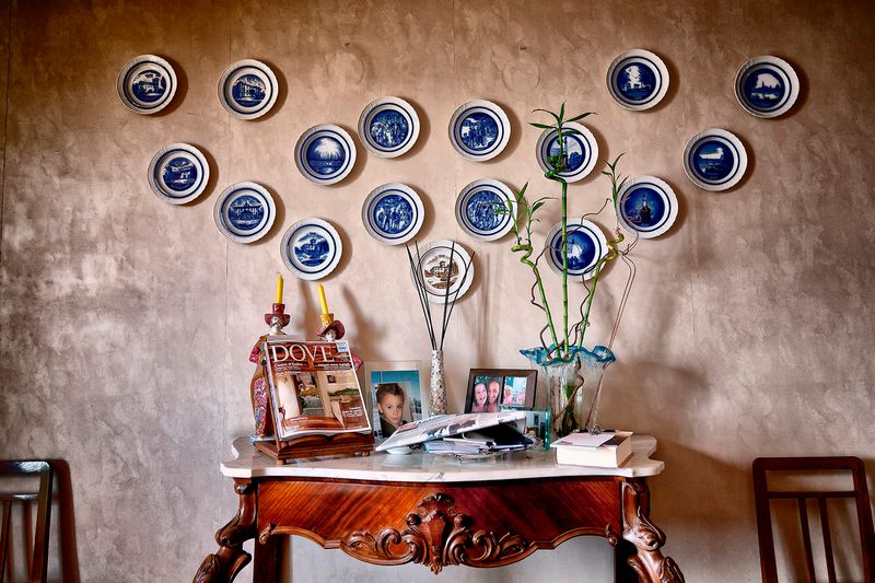© Simona Bonanno - Living room interior with decorative plates ant family photos.