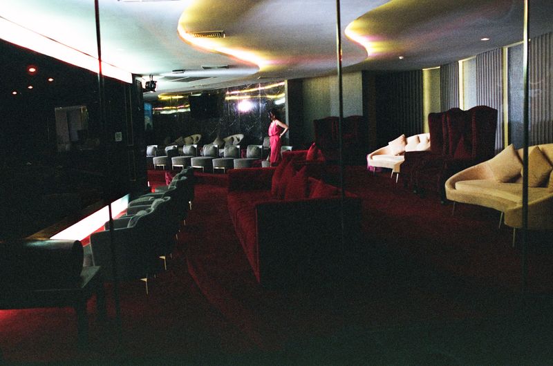 © Elizabeth Waterman - Long view of a model entering the lobby of a Pleasure Palace in Bangkok.