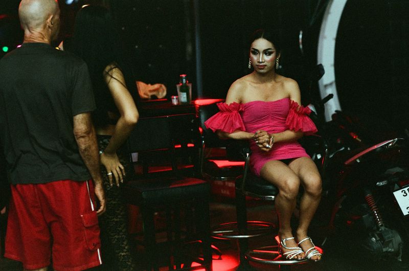 © Elizabeth Waterman - Ladyboys beckon to men outside their bar, encouraging them to come inside and buy them drinks.