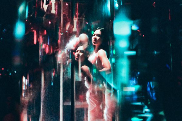 © Elizabeth Waterman - Dancers at a popular Nana plaza bar perform 'shower show,' where they dance and wash themselves while customers watch.