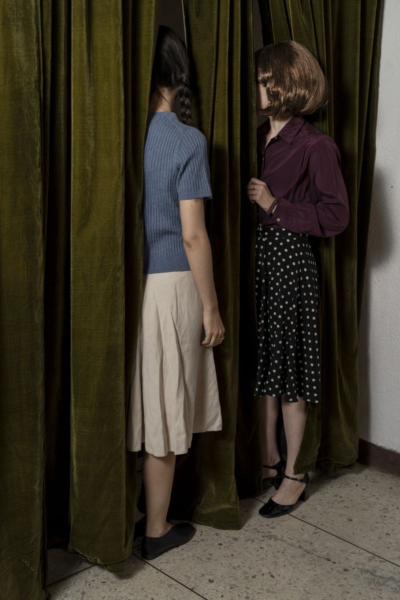 © Valeria Arendar - Behind the curtain, ordinary gestures of looking and whispering become entangled with gossip, suspicion, and paranoia.