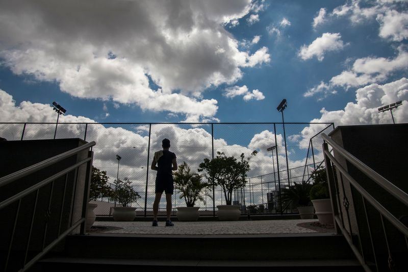 © Chiara Ferronato - A resident prepares to enter the tennis courtyard of the gated community where he lives.