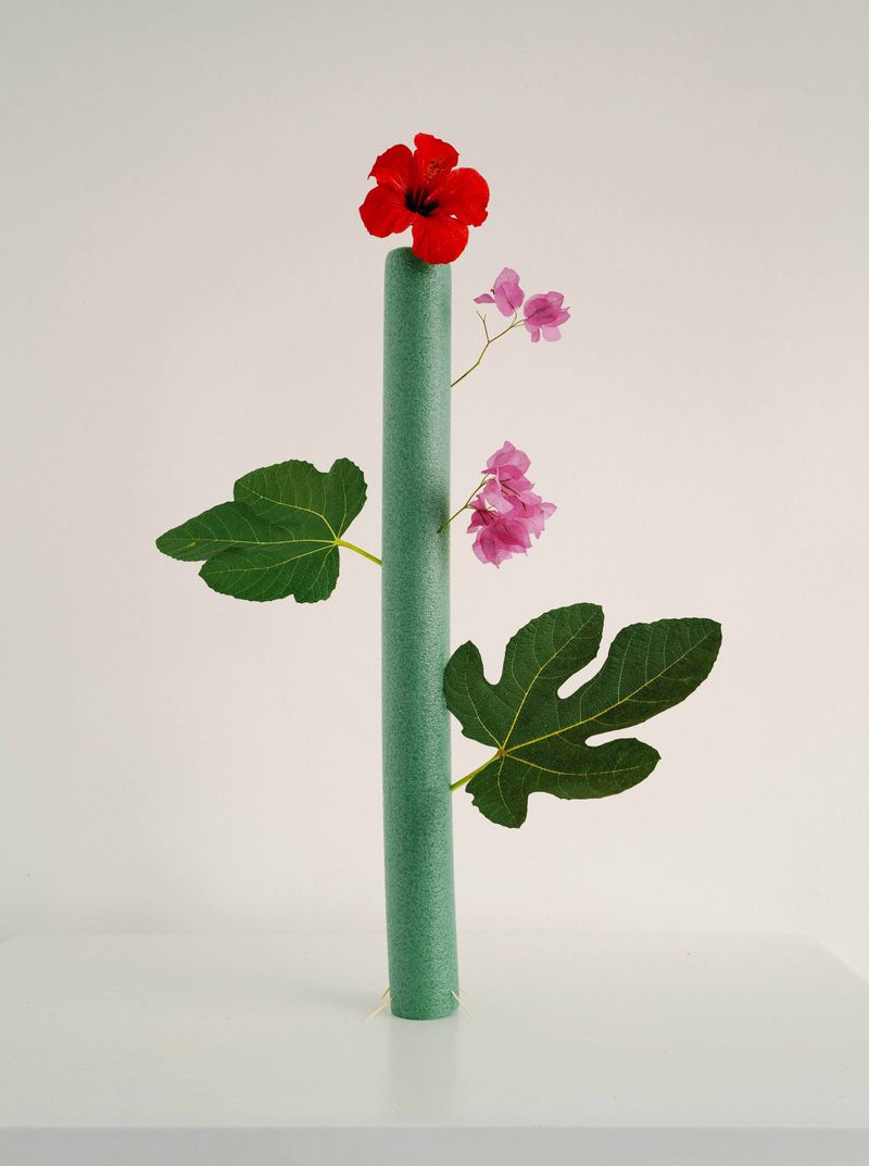 © Nikita Lukyanov - a flower through the plastic pool noodle / installation with a leaves and flowers from the hotel garden
