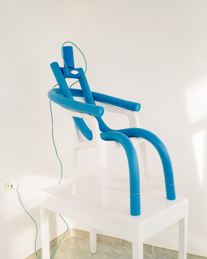 © Nikita Lukyanov - a man / character with plastic noodle sticks and white plastic chair