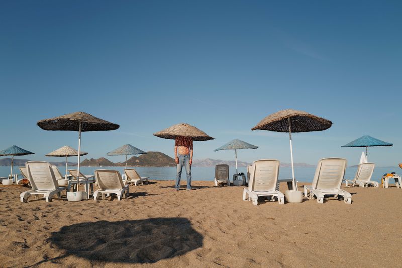 © Nikita Lukyanov - a man on the beach with the big hat