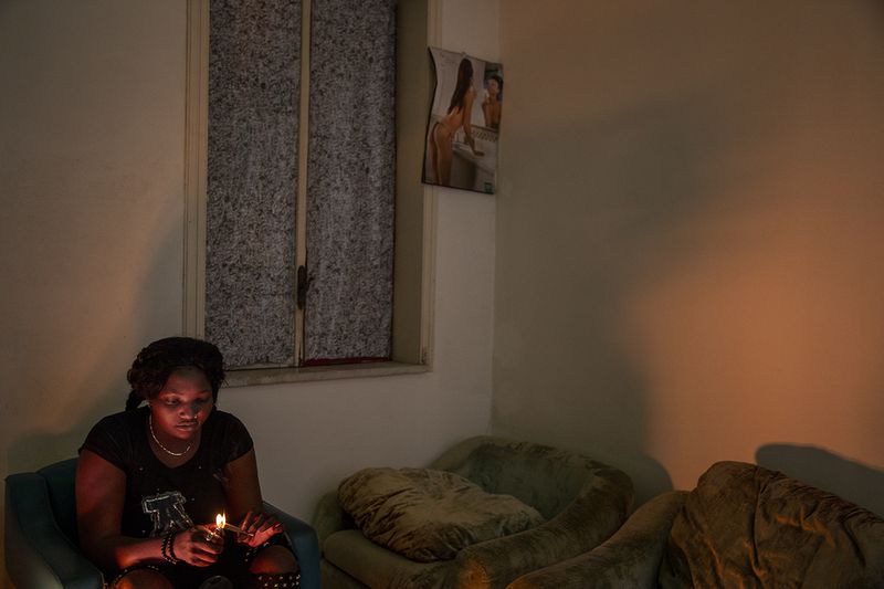 © Alessio Paduano - Q., 21 years old from Nigeria, consumes marijuana at her friend's house in Castelvolturno, Southern Italy on April 16, 2018.