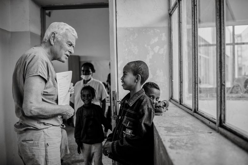 © Carlo Perazzolo - Prof. Giovanni Stellin (Head of Surgery, Med.Action) talks with a child in screening area.