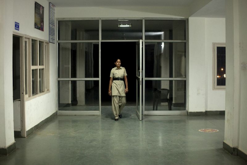 © Melanie Dornier - Night duty, AWPS, Gurugram, Haryana, India, 2016.Constable Manju is checking the outside of the AWPS.