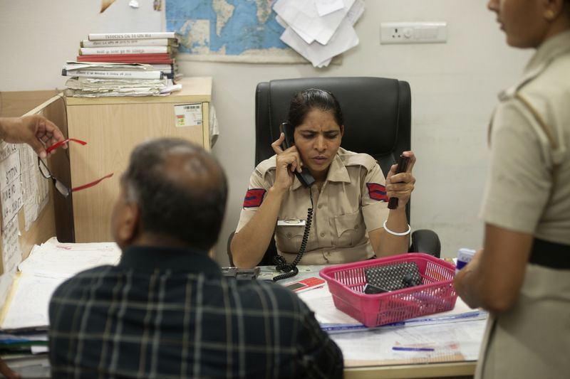 © Melanie Dornier - Entry desk, AWPS, Gurugram, Haryana, India, 2016.Head Constable Bala is conversing on the AWPS’ phone.