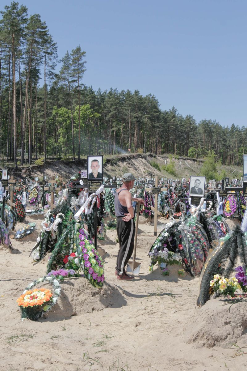 © Nazar Furyk - 3. A cemetery worker looks at the fresh graves of murdered and tortured locals. Irpin town. May, 2022.