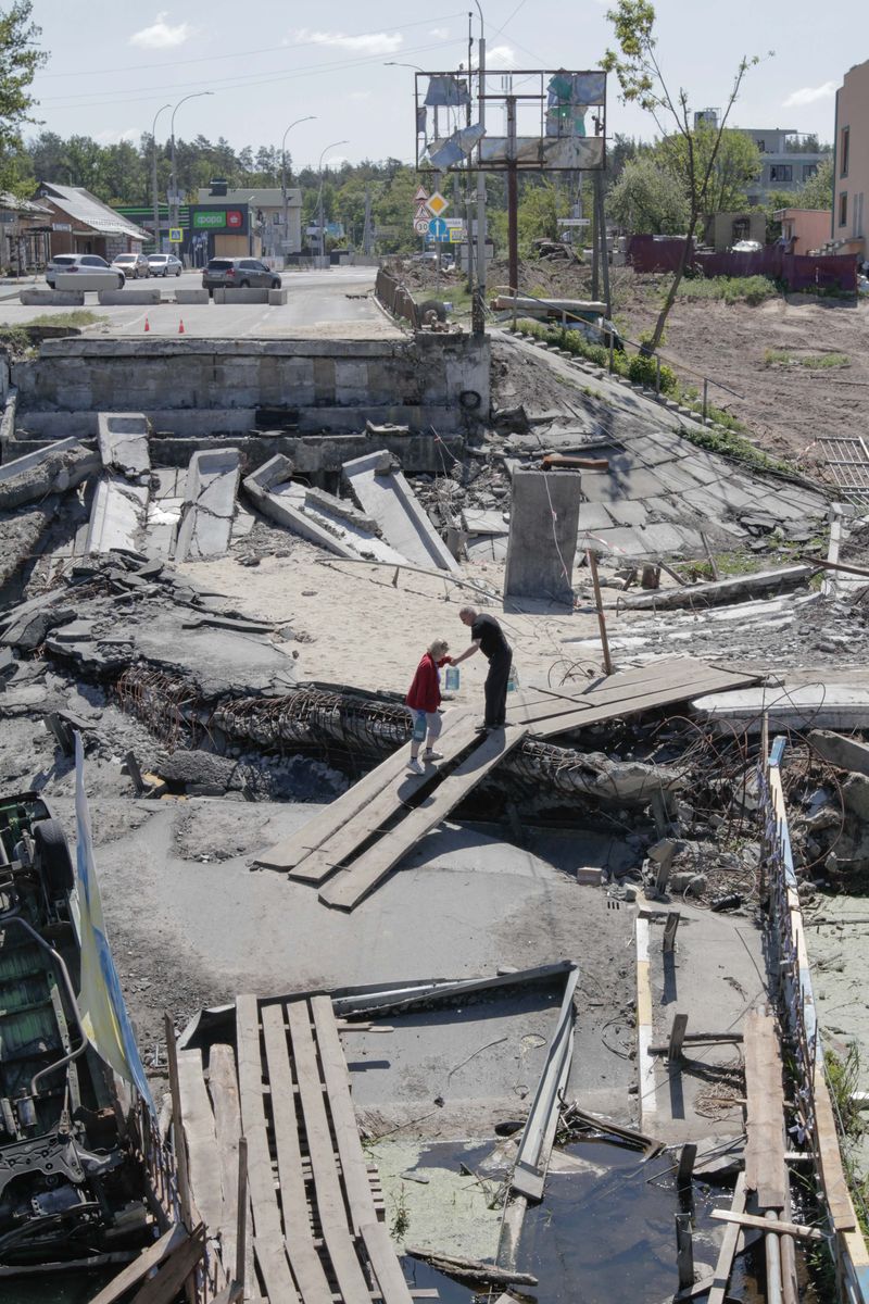© Nazar Furyk - 1. An old couple walks through the destroyed Irpin’s bridge with bottles of water. May, 2022.
