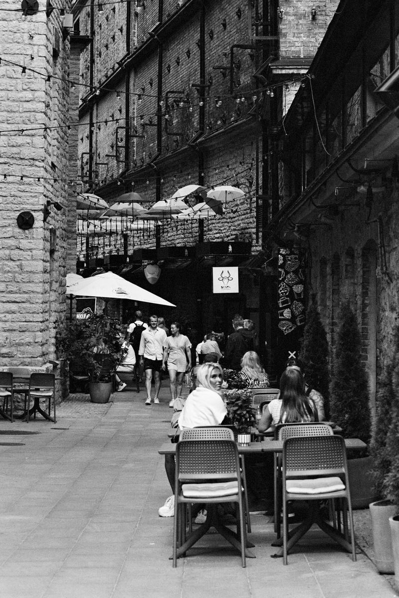 © Ksenia Shupenya - Café scene, tables and people - a narrative of communal everyday life. Ilford XP2 Super