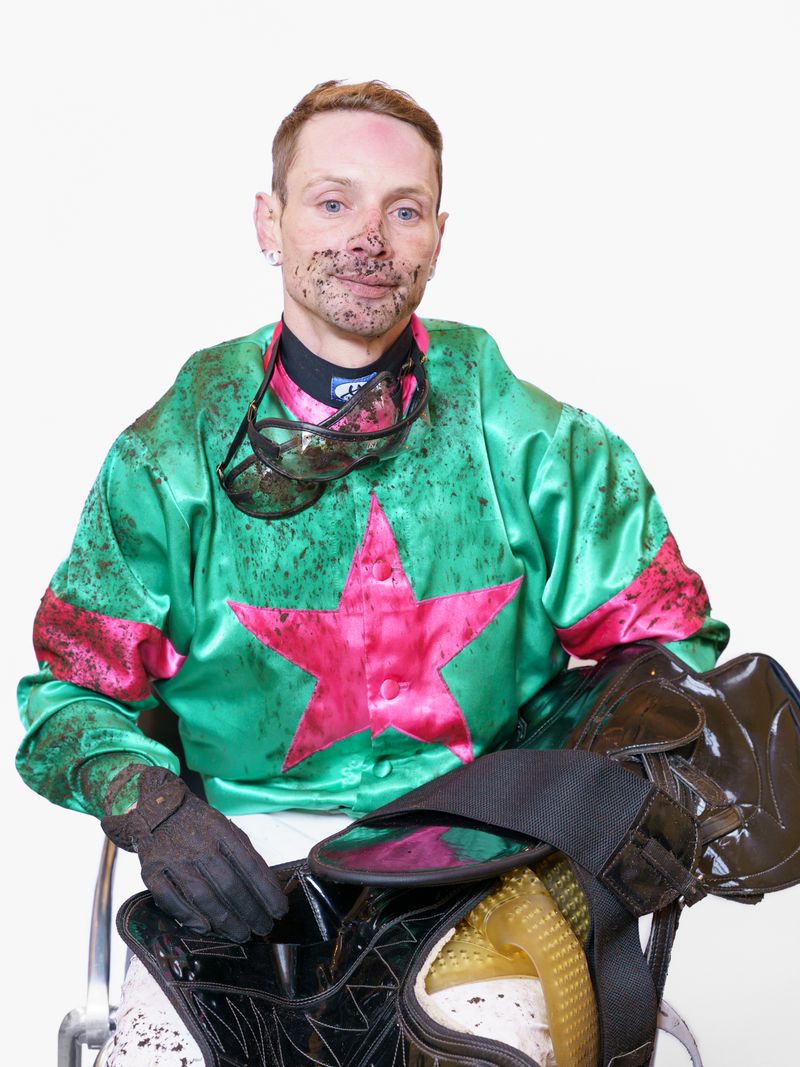 © Theresa Wißmann - A jockey is being weighed on the weighing chair after the race. The goggles he wore during the race left a mark on his face.