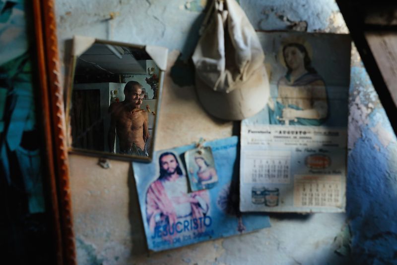 © Oded Wagenstein - Havinyo Agiar's image is reflected through a broken mirror in his one room apartment, Cienfuegos, Cuba