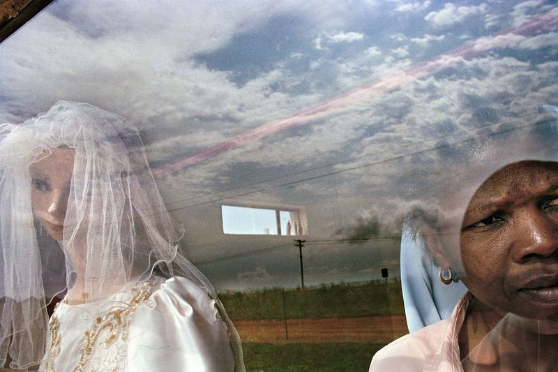 © Graeme Williams - Glen Cowie, South Africa. 2005. A woman peers out of her dressmaking shop.