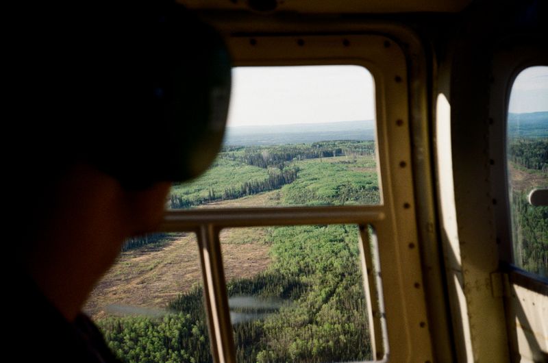 © Aidan Clark - Looking out the Jet Ranger helicopter as we fly to the cut-block.