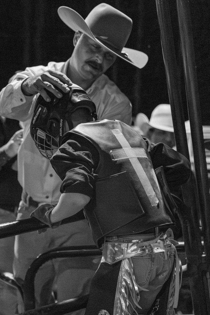 © Rian Nelson - A father prays over his young son as he prepares to compete in the pony bucking event, a step stone to bull riding.