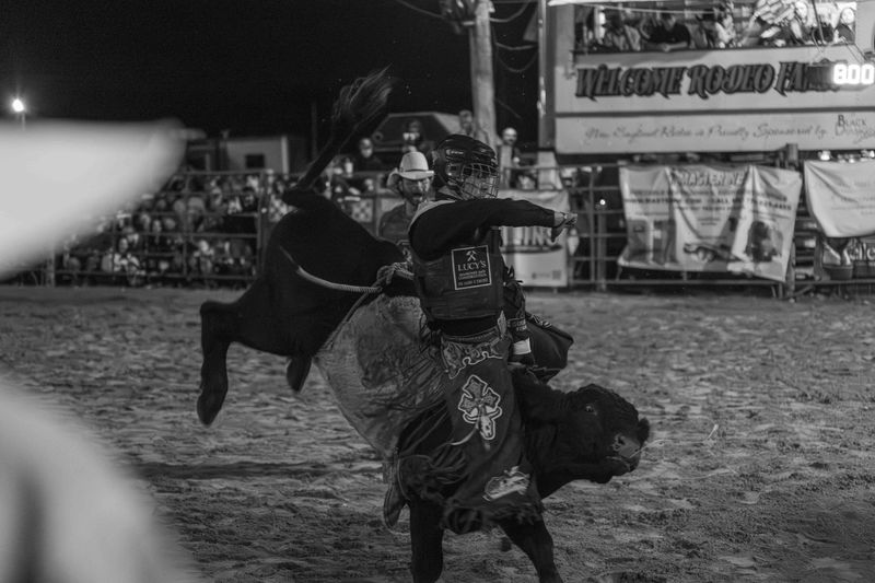 © Rian Nelson - A bullrider successfully reaches 8 seconds, and moments later is thrown from the bull as it rears and twist simultaneously.