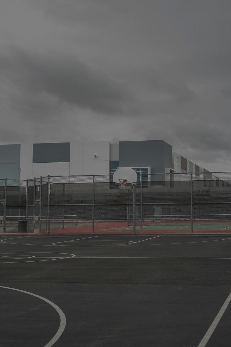 © Vera Saldivar - FedEx warehouses seen from a local highschool's basketball court in Fontana