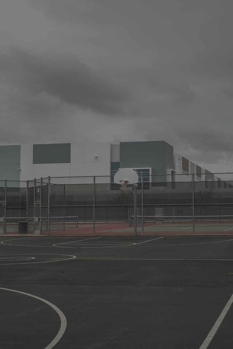© Vera Saldivar - FedEx warehouses seen from a local highschool's basketball court in Fontana