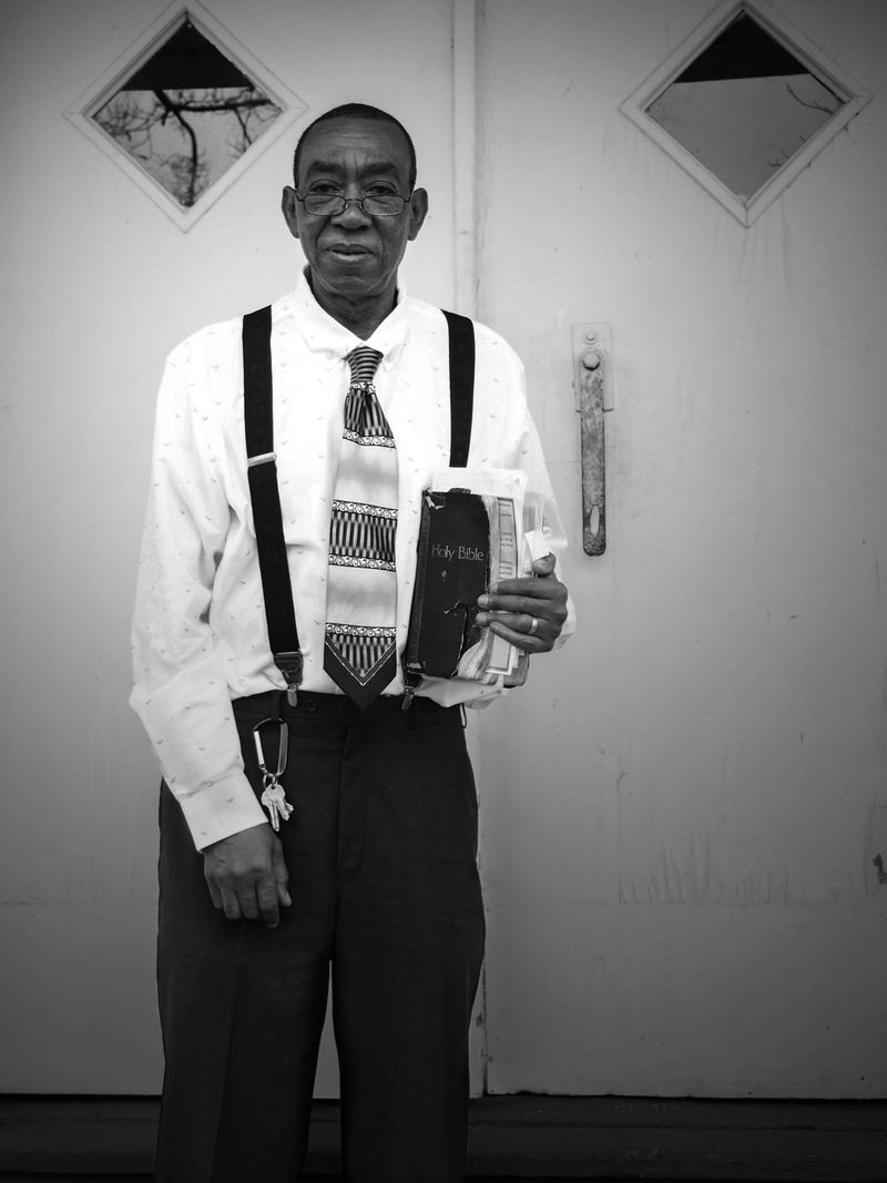 © Rebecca Moseman - Preacher Man. Mr. Hoover, the local preacher of the Mt. Zion church stand outside the church doors after the Sunday service.