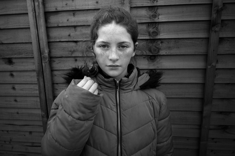 © Rebecca Moseman - Biddy, a pre-teen traveler, poses outside her shed, showcasing her family's new halting site.