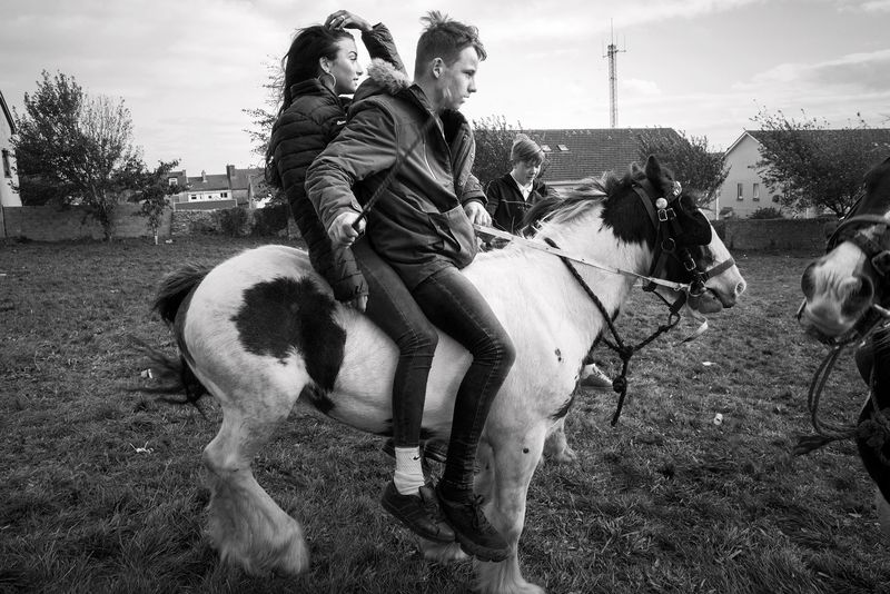 © Rebecca Moseman - A group of Irish Traveler teenagers ride around the fairgrounds on their horses.
