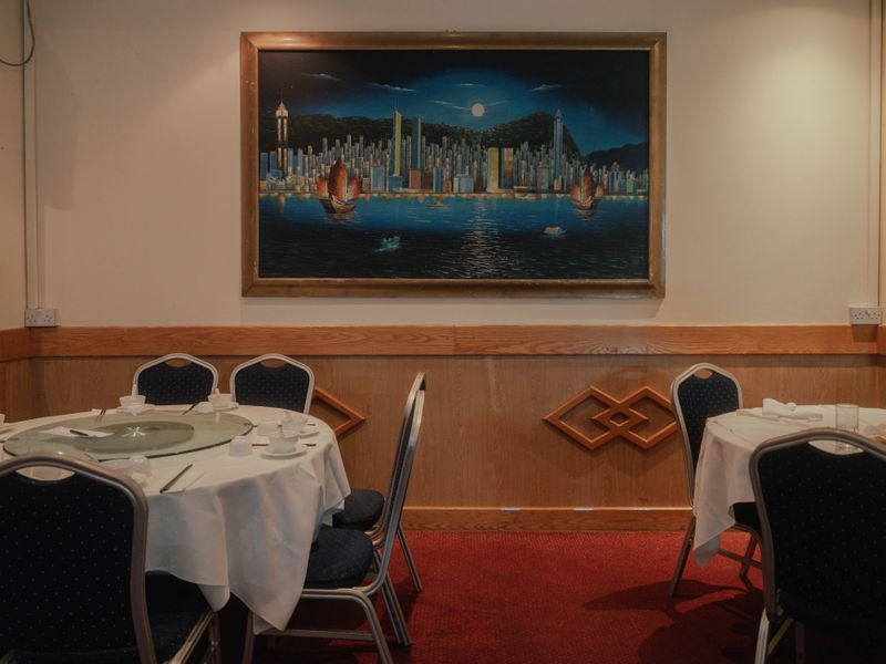 © Siu Bon Deacon Lui - A Chinese restaurant in London displaying a large painting of Hong Kong's iconic night view at Victoria Harbour.
