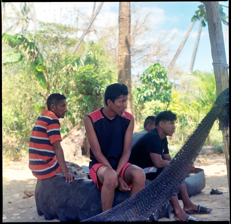 © Kelly-Ann Bobb - Young Warao men sit in conversation in Icacos, Trinidad.