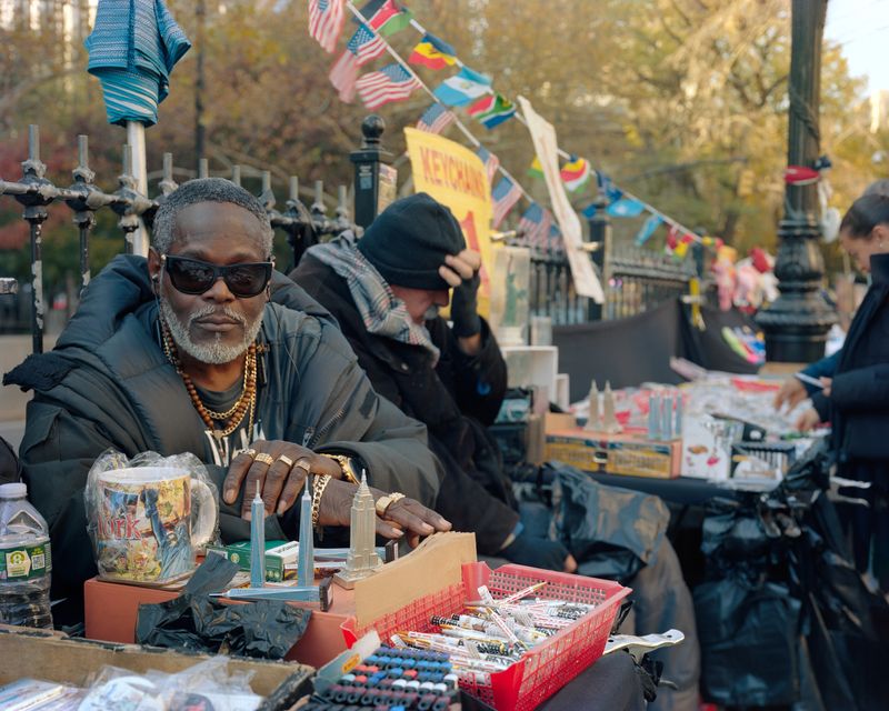 © Dawn Kim - "Mellow" selling souvenirs at the mouth of the Brooklyn Bridge, Manhattan, New York, 2024