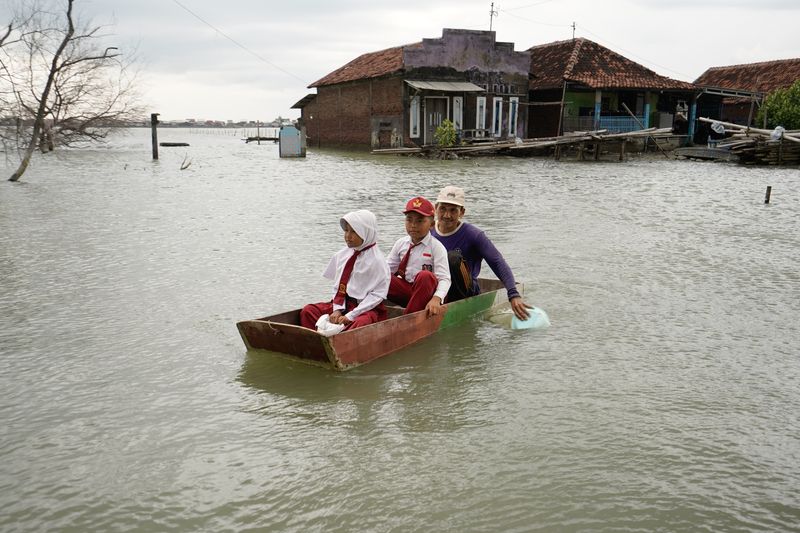 © Pakak Banak - A father takes his two children to school by boat, using a dinner plate to paddle
