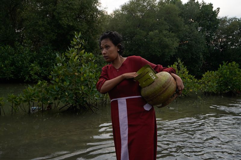 © Pakak Banak - Residents buy gas cylinders for cooking and pass through streets that are flooded by seawater every day